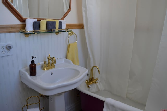 bathroom featuring a bathing tub and wooden walls