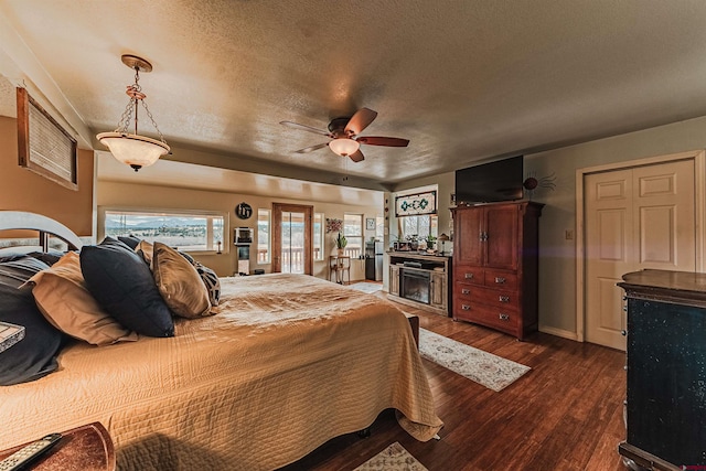 bedroom featuring ceiling fan, dark hardwood / wood-style flooring, and a textured ceiling