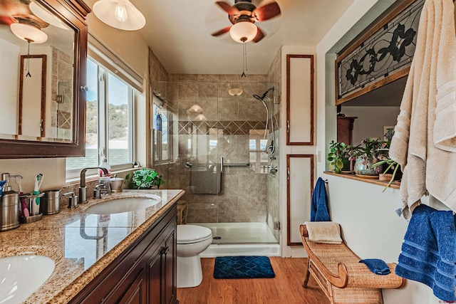 bathroom featuring ceiling fan, hardwood / wood-style floors, an enclosed shower, toilet, and vanity