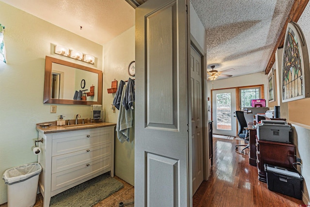 bathroom with ceiling fan, vanity, a textured ceiling, and hardwood / wood-style flooring