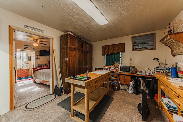 carpeted office space featuring ceiling fan and a textured ceiling