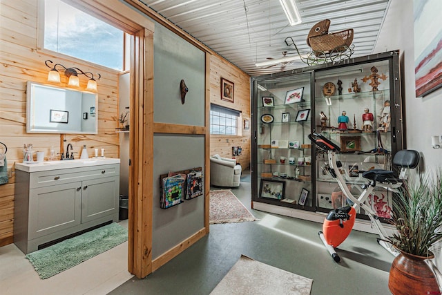 bathroom featuring concrete flooring, vanity, and wood walls