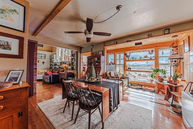 dining area with wood-type flooring, a textured ceiling, and a wealth of natural light