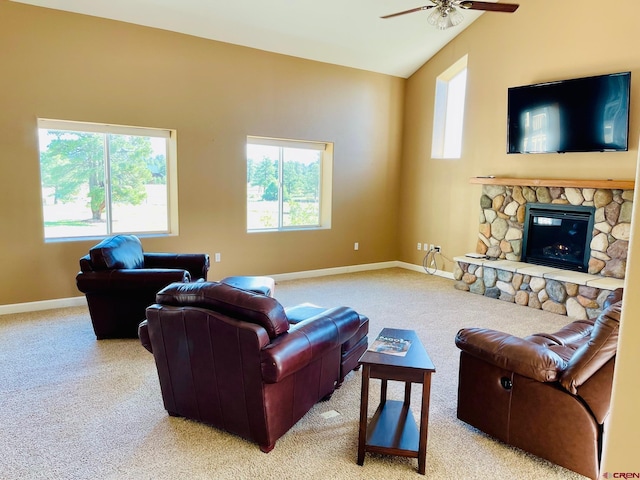 carpeted living room featuring a stone fireplace, ceiling fan, and lofted ceiling