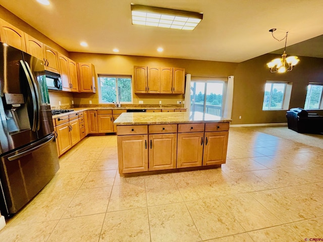 kitchen with refrigerator with ice dispenser, a chandelier, a wealth of natural light, and hanging light fixtures