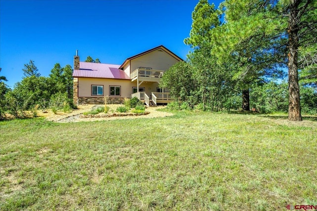 exterior space with a balcony and a lawn