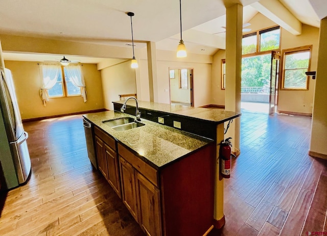 kitchen with lofted ceiling with beams, light hardwood / wood-style flooring, plenty of natural light, and sink