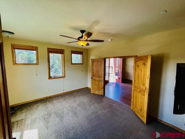 carpeted spare room with ceiling fan