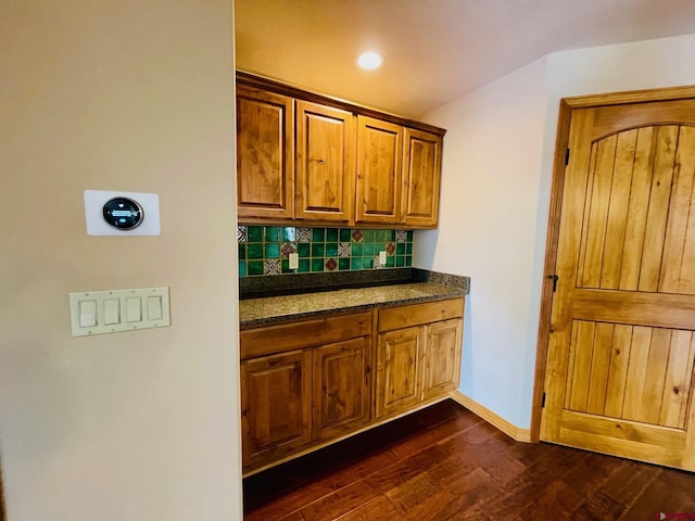 kitchen with dark hardwood / wood-style flooring and backsplash