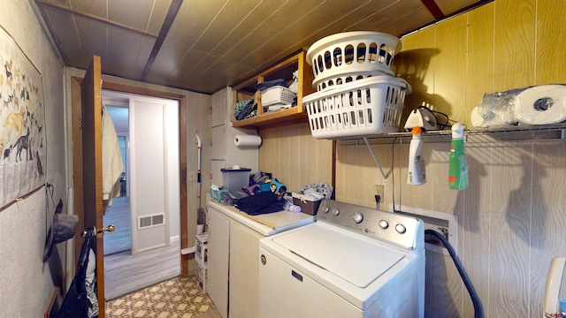 laundry area with washing machine and dryer, wood walls, and wooden ceiling