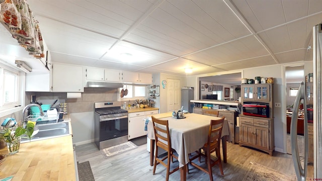 kitchen with white cabinetry, stainless steel range with gas cooktop, and a healthy amount of sunlight