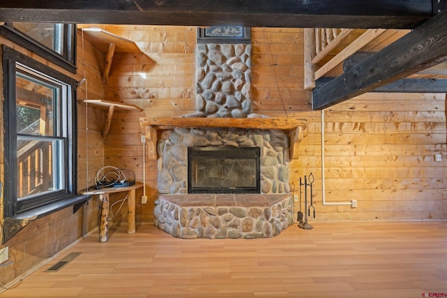 living room featuring a fireplace, wooden walls, hardwood / wood-style floors, and beamed ceiling