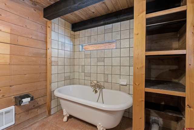 bathroom with tile patterned flooring, a bath, wooden walls, and wooden ceiling