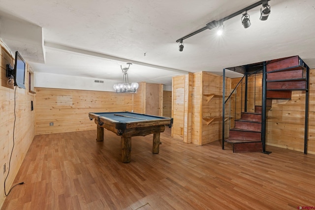 recreation room featuring rail lighting, wood-type flooring, a notable chandelier, billiards, and wood walls