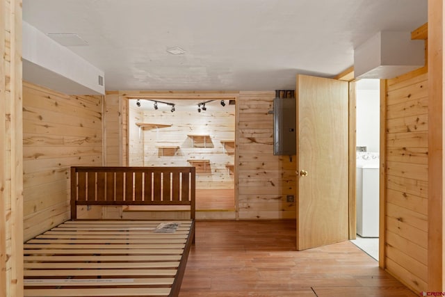 interior space featuring washer / clothes dryer, wood walls, hardwood / wood-style floors, and electric panel