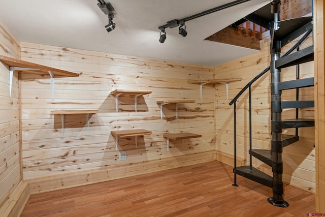 interior space with hardwood / wood-style flooring and wooden walls