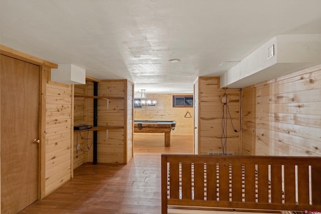 interior space with wood-type flooring and wooden walls