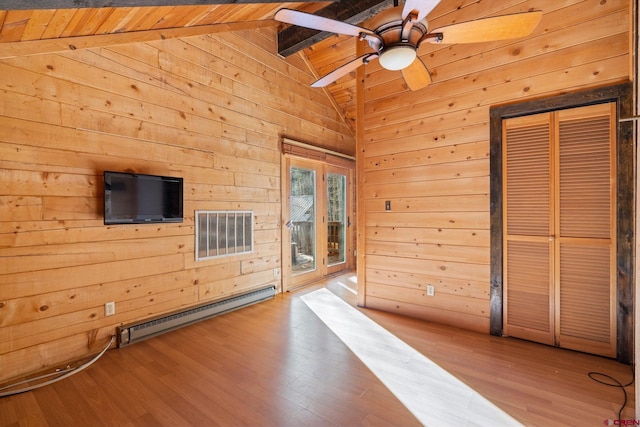 unfurnished living room featuring vaulted ceiling with beams, light hardwood / wood-style floors, baseboard heating, and wood walls