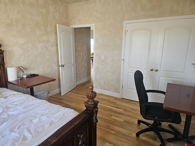 bedroom with light hardwood / wood-style flooring and a closet