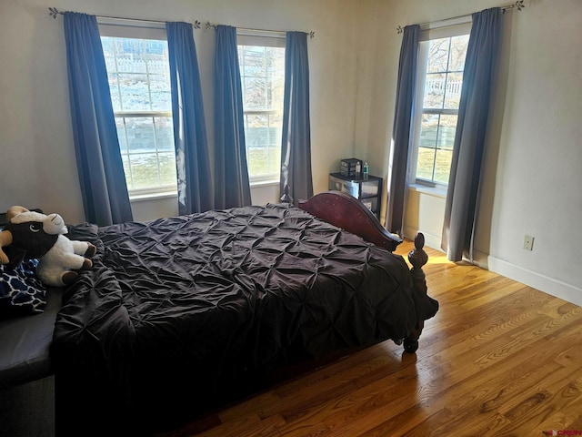 bedroom featuring hardwood / wood-style flooring and multiple windows