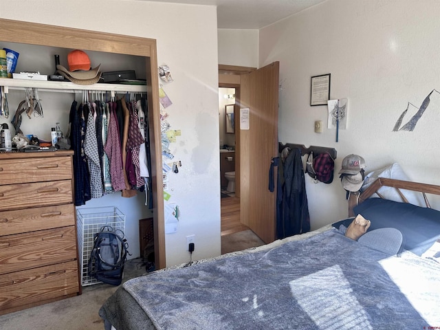 carpeted bedroom featuring connected bathroom and a closet