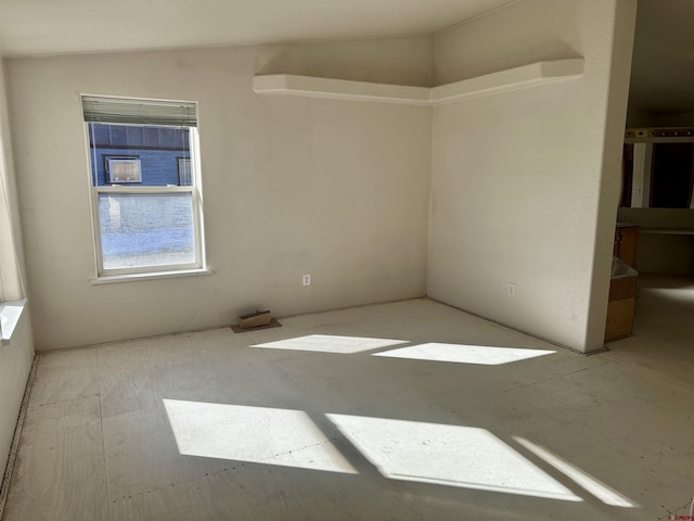 spare room featuring lofted ceiling