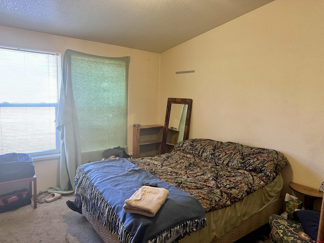 bedroom featuring carpet, a textured ceiling, and vaulted ceiling