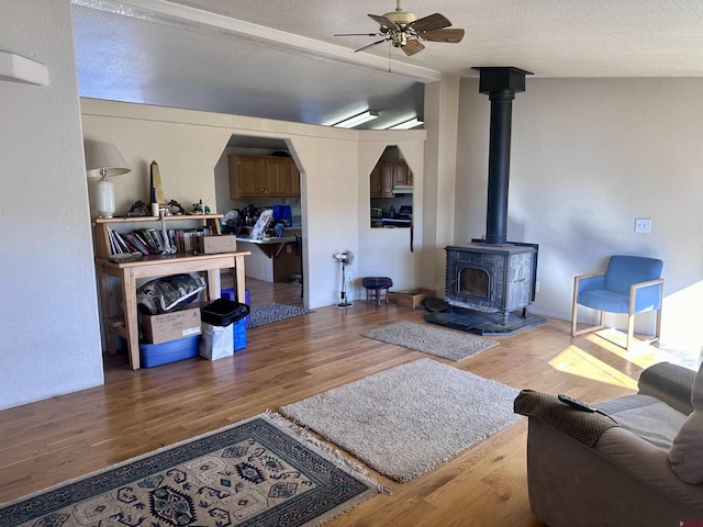 living room with hardwood / wood-style floors, vaulted ceiling, and a wood stove