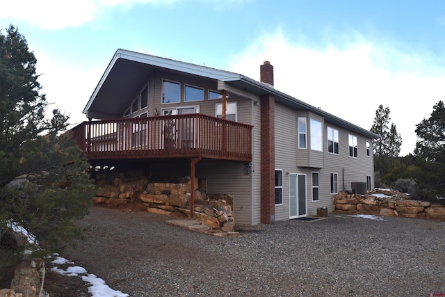 rear view of property with a deck and central AC