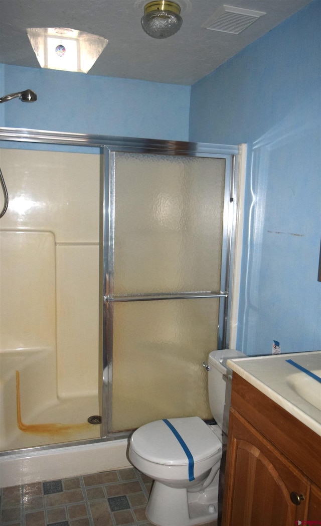 bathroom with toilet, an enclosed shower, and vanity