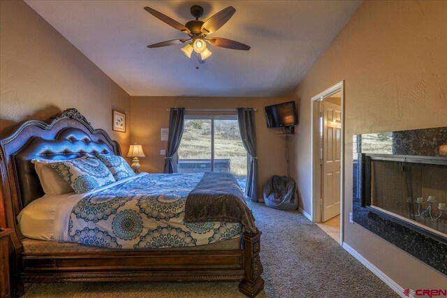 bedroom with ceiling fan, carpet floors, and lofted ceiling