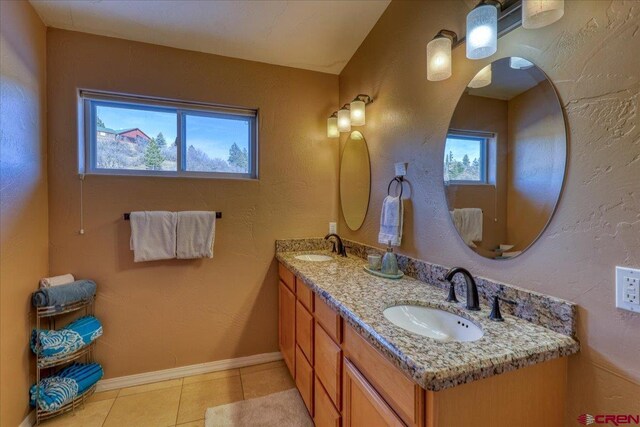 bathroom featuring a wealth of natural light, tile patterned flooring, and vanity