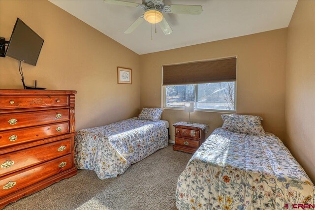 carpeted bedroom with vaulted ceiling and ceiling fan