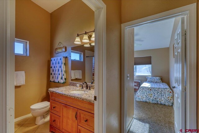 bathroom with tile patterned floors, vanity, toilet, and plenty of natural light