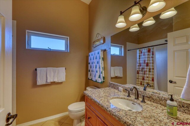 bathroom with toilet, plenty of natural light, vanity, and tile patterned flooring