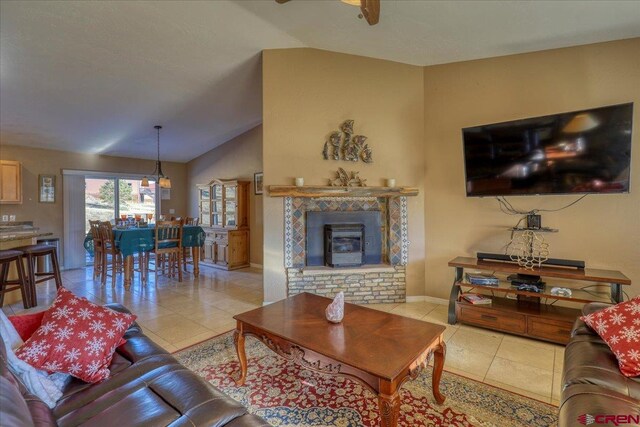 living room featuring ceiling fan, lofted ceiling, and light tile patterned floors