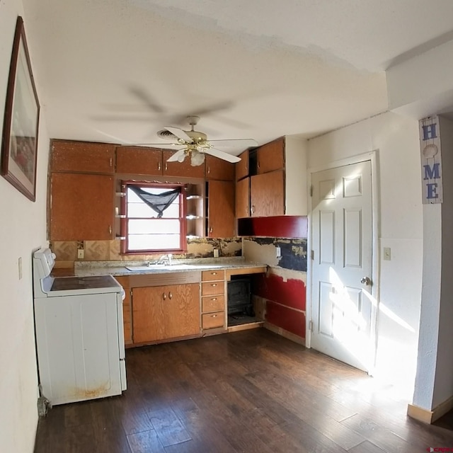 kitchen with ceiling fan, stove, dark wood-type flooring, and sink