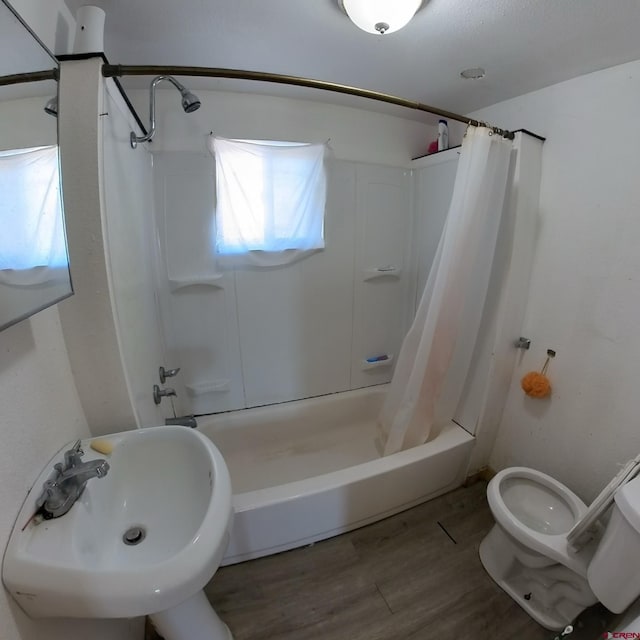 full bathroom with sink, shower / bathtub combination with curtain, wood-type flooring, and toilet