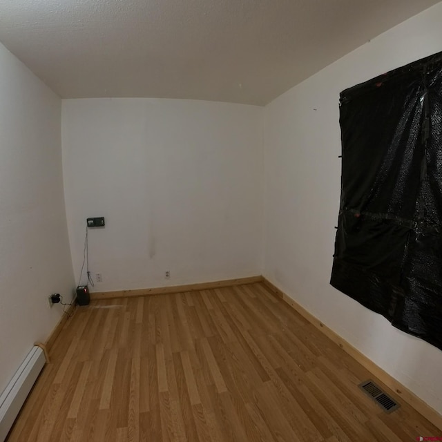 laundry room featuring light hardwood / wood-style flooring and baseboard heating