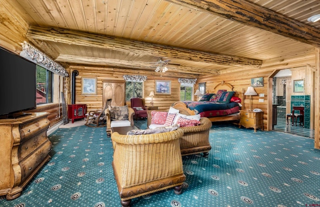 living room featuring beamed ceiling, a wood stove, rustic walls, and wooden ceiling