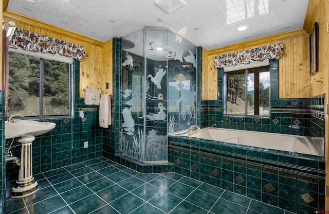 bathroom featuring a relaxing tiled tub, tile patterned floors, and tile walls