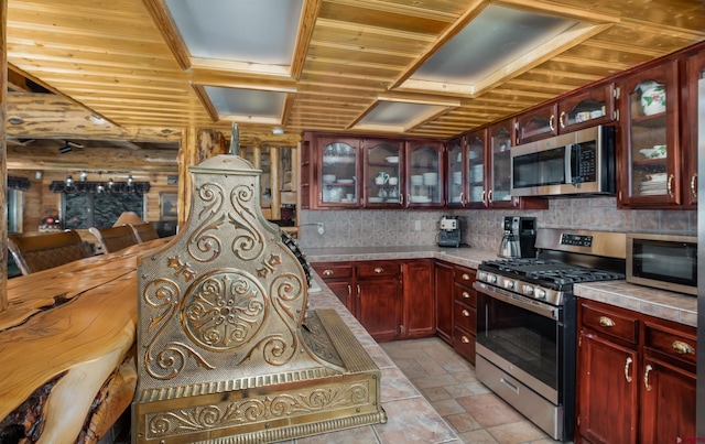 kitchen with decorative backsplash, wood walls, and stainless steel appliances