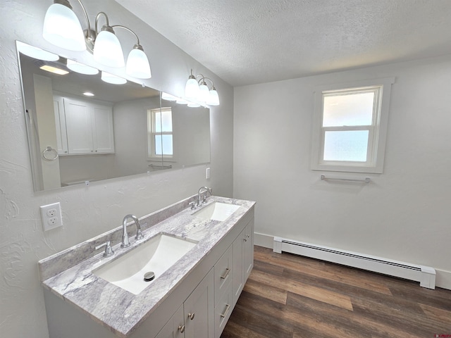 bathroom featuring vanity, hardwood / wood-style floors, a textured ceiling, and baseboard heating