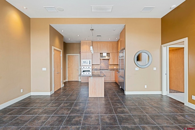 kitchen featuring wall chimney exhaust hood, stainless steel appliances, stone countertops, a center island, and hanging light fixtures