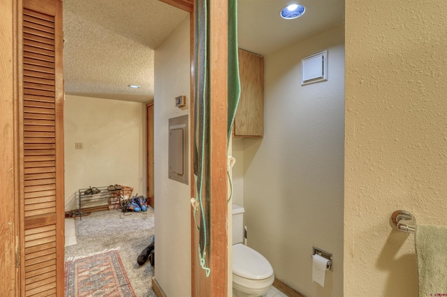 bathroom with a textured ceiling and toilet