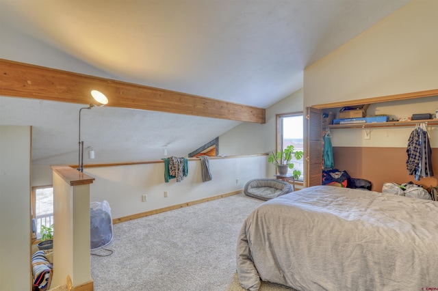 carpeted bedroom with vaulted ceiling with beams and a closet