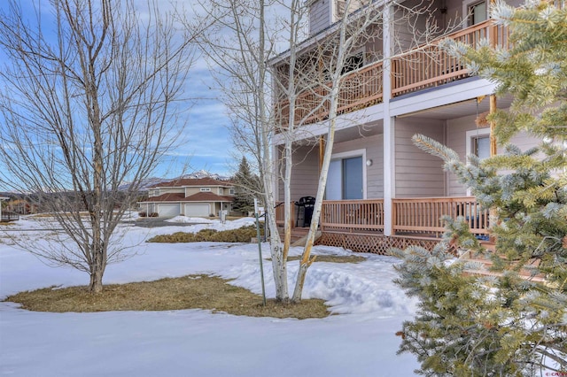 view of snowy exterior featuring a balcony