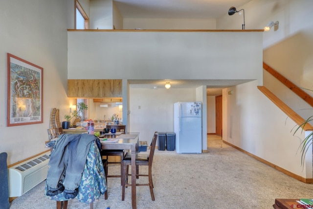 carpeted dining space with a high ceiling