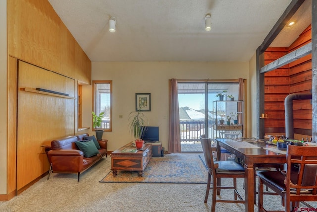 dining area with a textured ceiling and light colored carpet