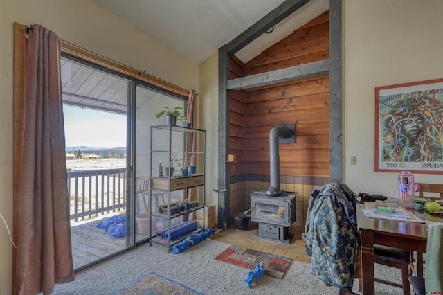 interior space with lofted ceiling, a wood stove, and light carpet